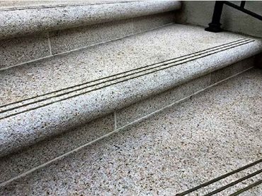 Radial stair treads and risers were handcrafted from Golden Dune Granite