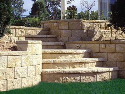 Outdoor image of sandstone retaining wall with garden bed
