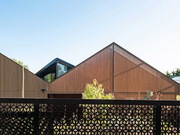 The striking facade invites natural light and maximises privacy for the residents