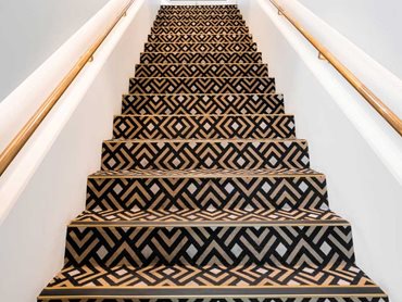 The spectacular colour palette of dark chocolate, gold and cream combines with the striking bold pattern to create a stunning custom carpet 