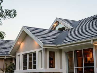 Detailed rooftop image of home with grey concrete roof tiles