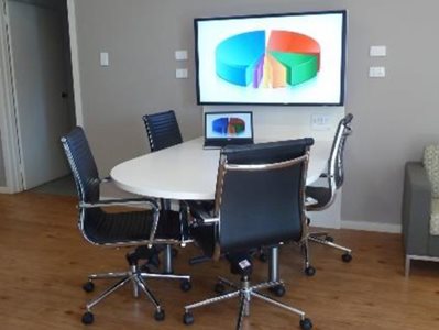 Open office meeting space with mounted display screen