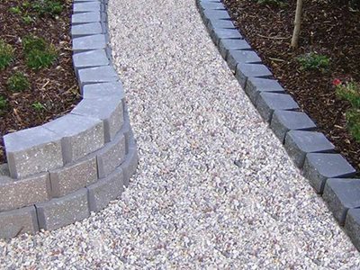 Outdoor garden gravel path bordered by masonry blocks