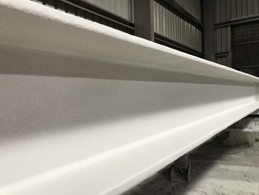 An inspection of a completed FIRETEX FX6002 beam reveals excellent aesthetic properties featuring a smooth texture and semi-gloss finish.