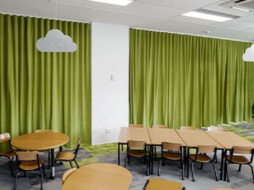 Acoustic curtains are drawn to create flexible learning spaces for small groups