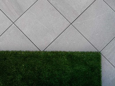 Detailed product image of synthetic turf next to tiles