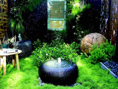 Lush outdoor garden with large round water feature