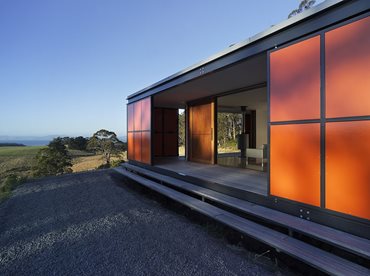 The Premaydena house sits on a low podium on a largely wooded site on the Tasman Peninsula. Photography by Peter Whyte