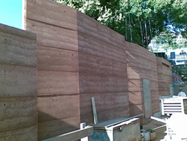 The 'rammed earth' wall is made of locally-sourced clay, sand and gravel