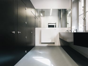 Custom-made, extra-height black Alpaco partitions provide superior privacy in the stunning washrooms