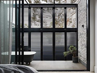 Petersen bricks are paired with aluminium plantation shutters for shading and privacy throughout the top storey
