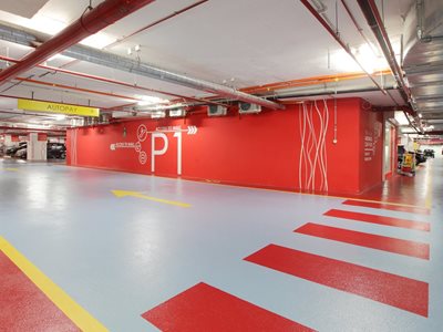 Detail of red underground car park with yellow wayfinding signs
