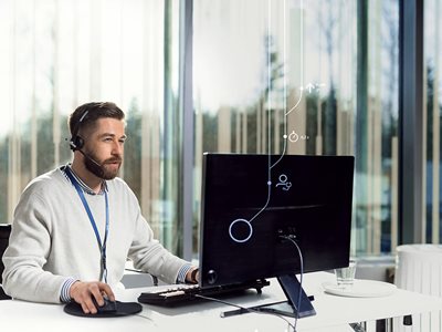 Kone Customer Care Center Operator with Headset in Front of Computer