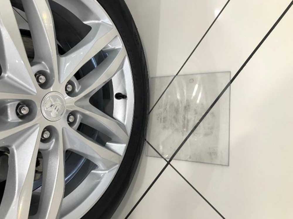 Polycarbonate pads protect car showroom floors from black tyre markings