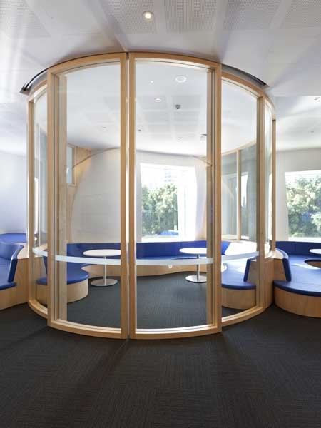 Large format curved glass bi-sliding doors welcome visitors to the area