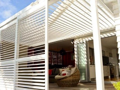 Outdoor room with large white shutters
