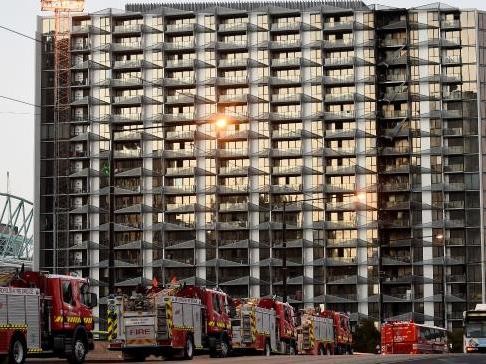 Firefighters at the apartment block the morning after the fire. Photography by Nicole Garmston/Image: Herald Sun
