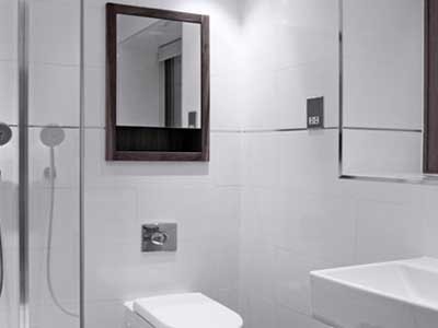A bathroom featuring white wall tiles
