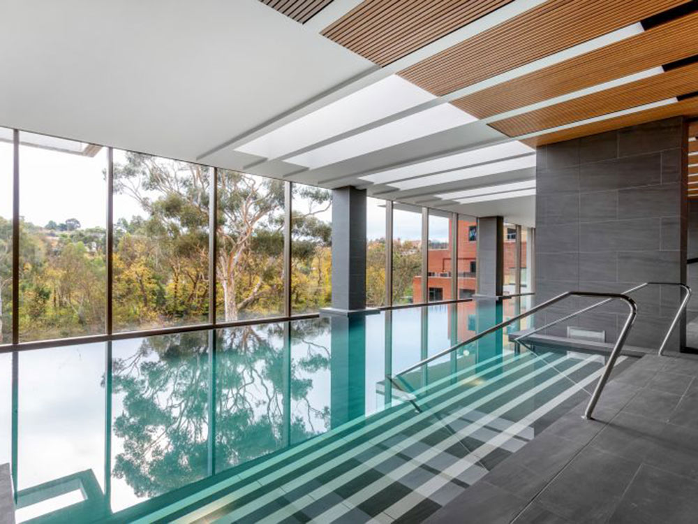 The 25-metre swimming pool features WoodEx battens in Blackbutt Light